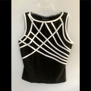 Black knit top with white satiny trim and sheer mesh at top.